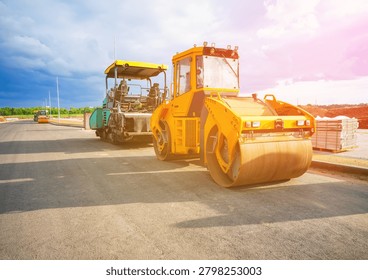 Road roller on asphalt road construction. Vibrator compactor machine on roadworks, asphalt pavement. Asphalt paving installation. Vibration roller on highway asphalting. Road compaction equipment. Special construction equipment for compact and smooth ground. Vibratory Roller, Double Drum or Tandem. 