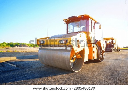 Road roller on asphalt road construction. Vibrator compactor machine on roadworks, asphalt pavement. Asphalt paving installation. Vibration roller on highway asphalting. Road compaction equipment. Special construction equipment for compact and smooth ground. Vibratory Roller, Double Drum or Tandem. 