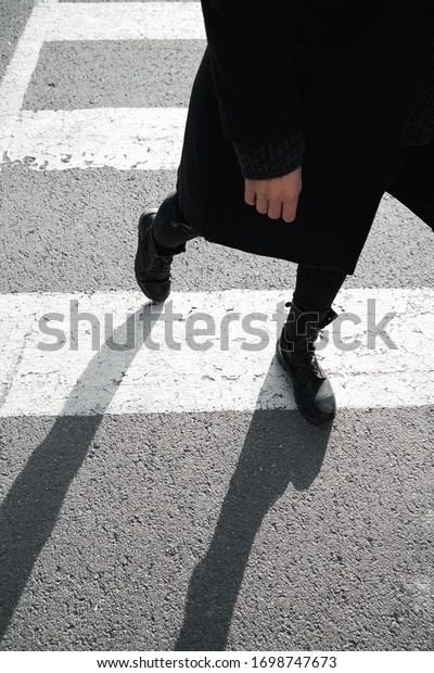 Road safety concept. A pedestrian\
crosses the road on a road marking. Pedestrian and\
driver