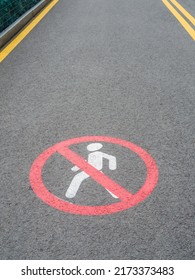 Road section with road markings regulating the movement of pedestrians. No pedestrians Allowed. Circular traffic sign. White man Symbol Painted over gray Asphalt. Signs drawn on the pavement - Shutterstock ID 2173373483