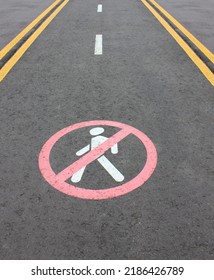 Road section with road markings regulating the movement of pedestrians. No pedestrians Allowed. Circular traffic sign. White man Symbol Painted over gray Asphalt. Signs drawn on the pavement - Shutterstock ID 2186426789