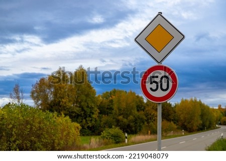 road sign with 50 kroad sign with 50 kmh and right of way, Germany in autumnmh and right of way, Germany in autumn. High quality photo