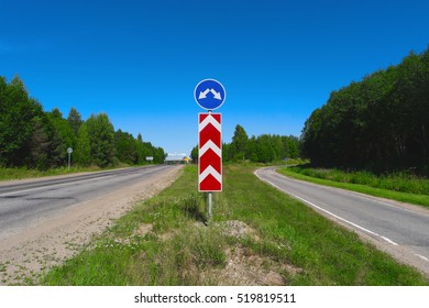 Road Sign With Arrows. Two Different Directions. Concept Of Choose The Correct Way. Right And Left Directional Traffic Signpost. Crossroad Sign. Empty Highway. Junction, Fork, Split Road Sign Post.