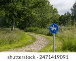 Road sign indicating a bridle path with the bridle path next to it.