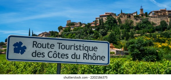 Road sign. (Inscription in english "Tourist Route Cote du Rhone"). Outside sign against blue sky, green vineyards. Incredibly scenic drive through the southern Cotes-du-Rhone Villages. - Shutterstock ID 2202186375