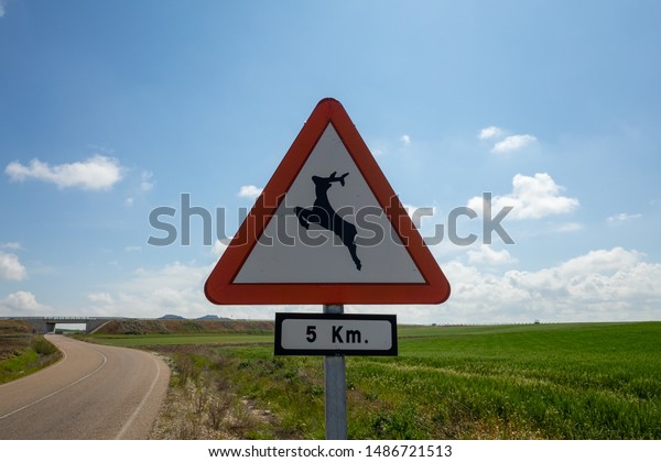 Road sign with\
jumping deer by the country\
road