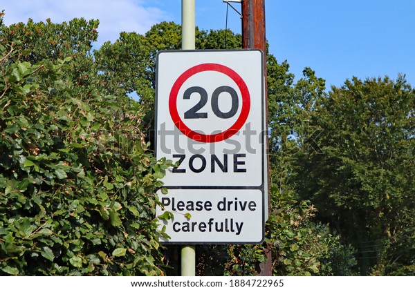 A road sign marking the start of a\
twenty miles per hour sign close to the village\
school