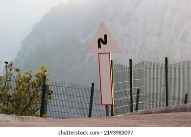 Road Sign In The Mountains. Warning Of Winding Road Ahead.