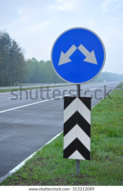 road sign on the highway. the arrows indicate the\
direction of motion