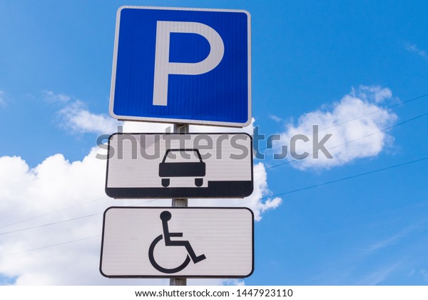 Road sign parking against the blue sky.\
Parking sign for disabled people.\
Close-up.