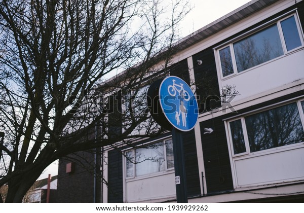 Road sign, pedestrian and bicyclist road sign. \
Circular blue traffic sign. Single object, white silhouette of a\
man holding a baby, and a\
bicycle