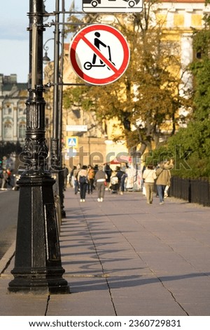 Road sign prohibiting riding electric scooters. Pedestrian street with people. Admiralteyskaya embankment, Saint-Petersburg, Russia