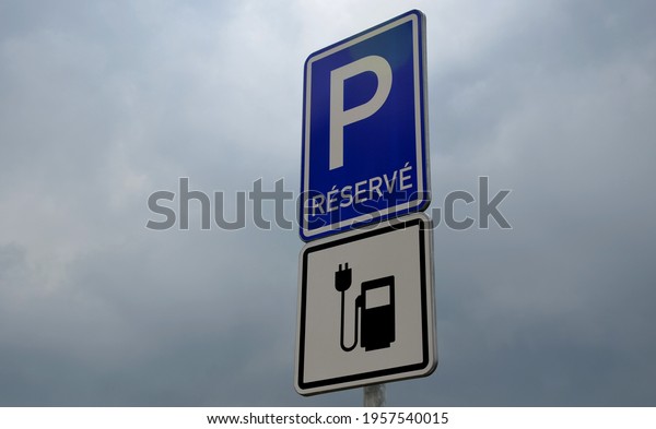 road sign reserves reservations for electric\
cars. Charging station with petrol stand symbol with cable and plug\
for electric battery\
charging