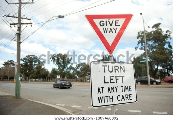 Road sign Turn left at any time with\
care. Australia, Melbourne. Warning sign.  Give\
way.
