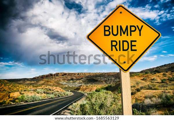 Road sign warning about a Bumpy Ride\
ahead on deserted scenic summer desert highway\
