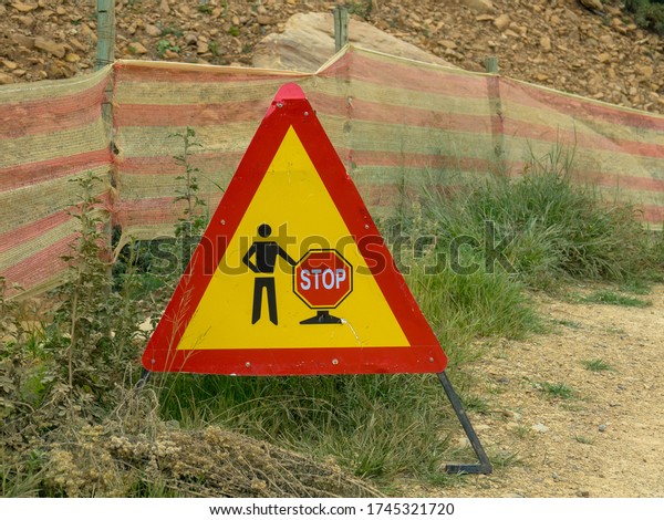 Road sign warning of road works against a dirt\
road, Sani Pass South\
africa