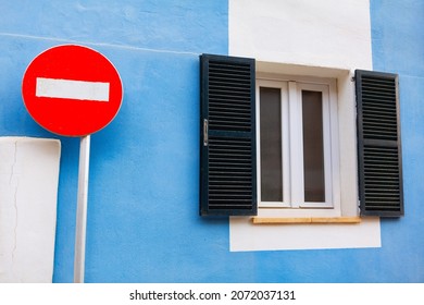 Road Sign And Window With Shutters . Road Sign No Entry . Rustic House With Blue Wall