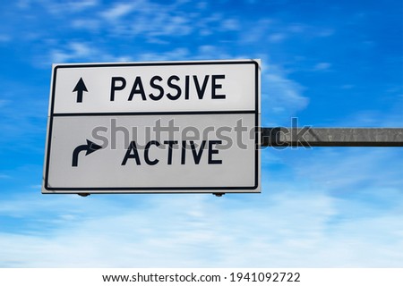 Road sign with words passive and active. White two street signs with arrow on metal pole. Directional road, Crossroads Road Sign, Two Arrow on blue sky background
