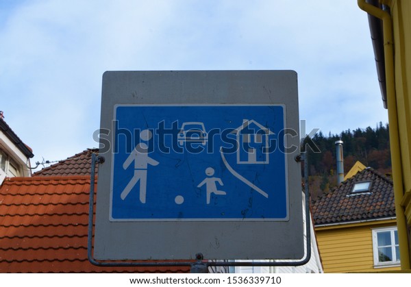 Road
signboard : A narrow street with many houses. Attention sign -
drive carefully, children might be on the
street