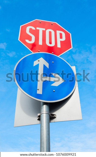 road signs with a direction of movement and a\
mandatory stop sign