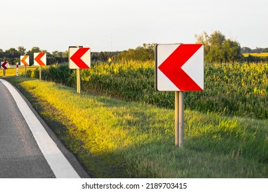 Road Signs In European Style Warn Of A Sharp Turn On A Narrow Road, A Sharp Turn