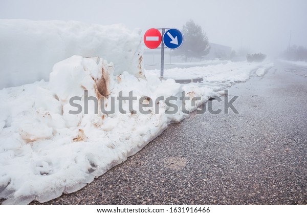 Road signs in\
the fog during a snow\
blizzard.