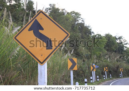 road signs indicating direction on curved road