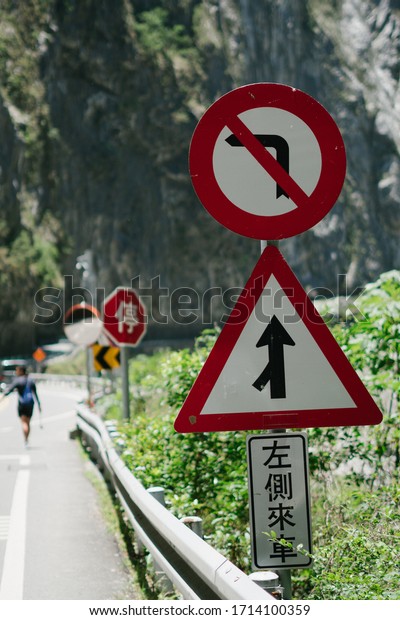 Road signs indicating no left turn, and a left merging\
laine. The chinese word reads \