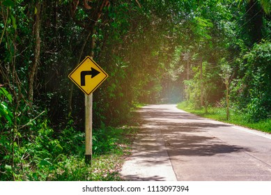 Road signs, indicating right turn on curve road. Turning right. Signal for safety or caution. Traffic warning sign for safe drive on empty curved road or path. Driving on forest road. Safety concept.