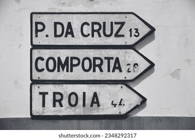 Road signs in Melides, Alentejo, directing the way to Pinheiro da Cruz, Comporta, and Troia. - Shutterstock ID 2348292317