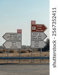 Road signs in the Negev Desert in Israel. Highway 90 with signs for Jerusalem and Jerico pointing in one direction and the Dead Sea and Eilat pointing in the other direction.
