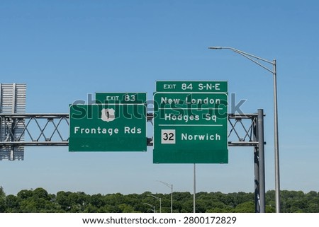 road signs on Interstate 95 for exit 83 to US-1, Frontage Roads and exit 84 S-N-E toward New London, Connecticut, Hodges Square , and CT-32 Norwich
