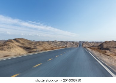 Road Speed Motion Blur, Undulating Desert Wilderness Highway Against A Blue Sky