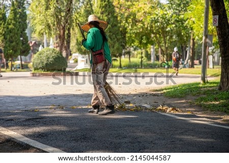 Road sweepers cleaning  streets with broom tools in  public park. image