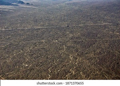 Road That Crosses In A Straight Line Through A Desert Of Black Sand Seen From The Sky In An Aerial Image And Where You Can See A Solitary Truck