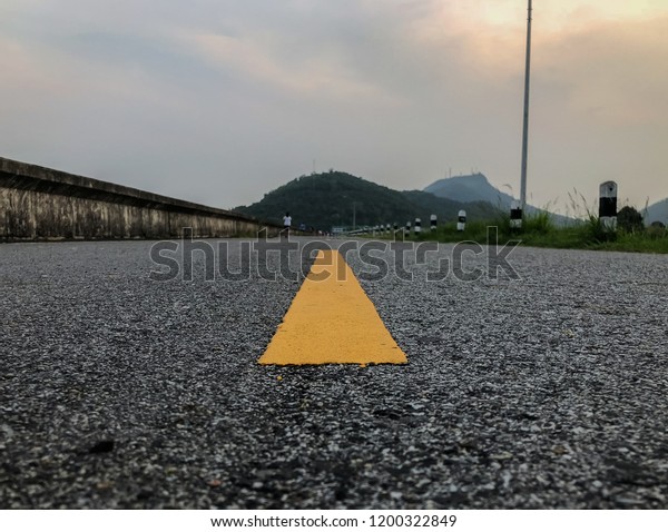 The road that has yellow stripe on middle\
with natural background.