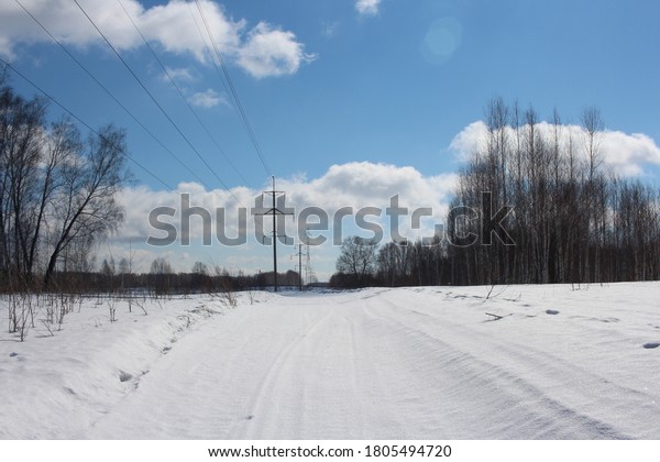 road through the forest with electric towers wires\
for driving cars in winter