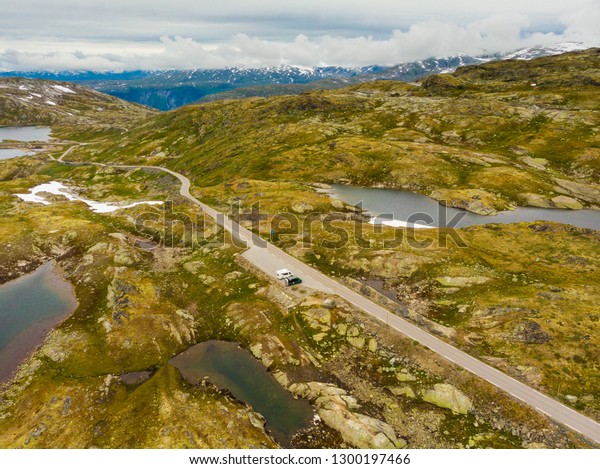 Road through mountains landscape. Camper cars on\
rest stop area. National tourist scenic route 55 Sognefjellet\
Norway. Aerial view