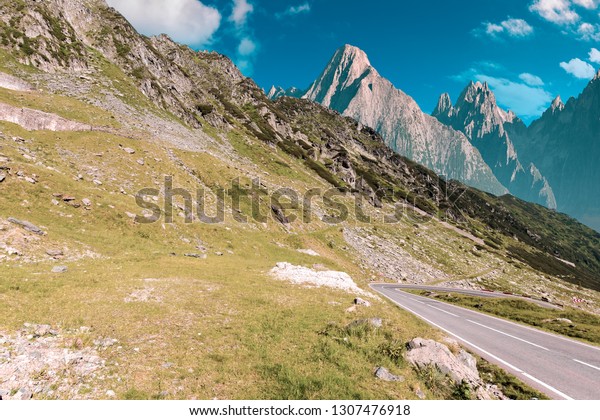 road through\
mountains with rocky cliff. summer travel concept. composite image\
with creative toning