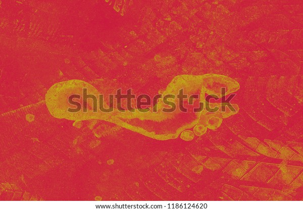 Road tire and\
the human footprint on the road. Background texture, pattern of red\
and yellow. Texture design of tires and legs. A footprint of a\
man\'s and machine\'s feet.
