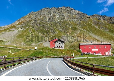 Road towards houses and mountain under blue sky on background at Great St Bernard Pass on the border between Italy and Switzerland. Foto d'archivio © 