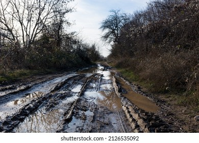 Road track in a countryside landscape with a muddy road. Extreme path rural dirt road in the hills with the muddy ground after rain
