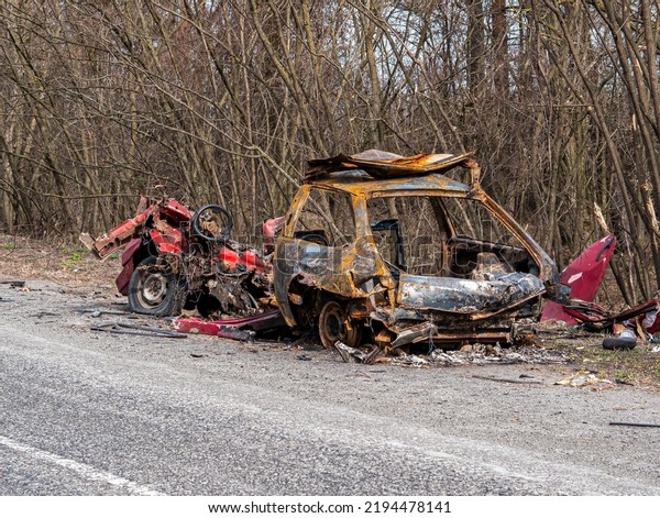 Road traffic accident of\
a car with fire. Car accident. Road in the forest. Damaged\
transport. Asphalt pavement. Traffic Laws. Military actions. Motor\
vehicle. Ukraine.