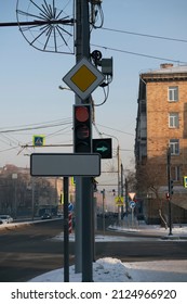 Road traffic light at the corner of an intersection in the city. Expensive traffic stop line and traffic priority signs. Regulation of traffic flow in the city.