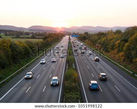 The road traffic on a motorway at sunset .