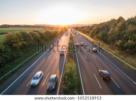 The road traffic on a motorway at sunset .