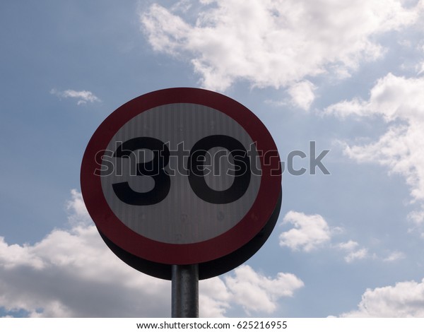 a road traffic sign with a sky background saying 30\
speed limit near school accident crash cars fast and slow warning\
police spring light