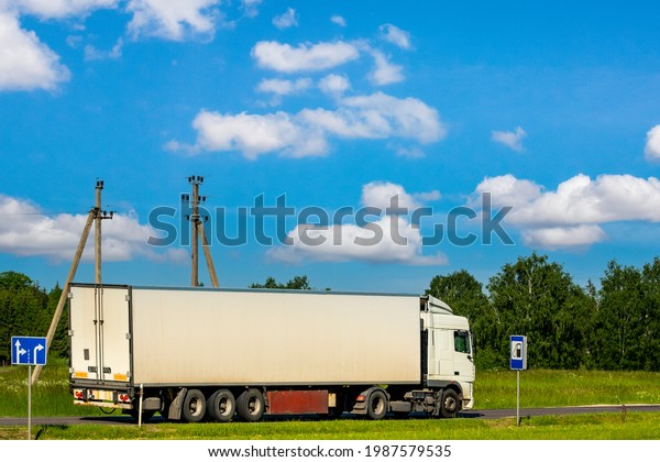Road transport of goods by truck.Truck\
driving on the asphalt road in rural landscape\
