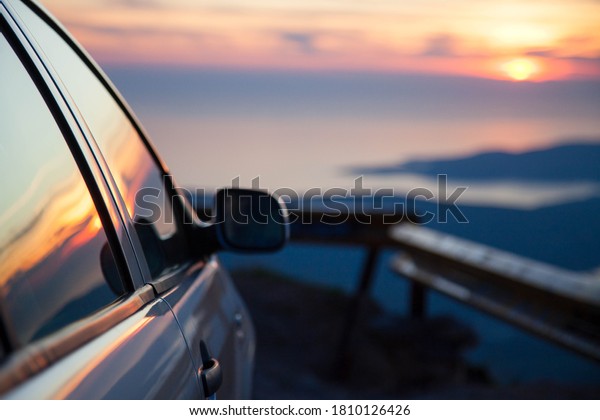 Road trip by car\
at sunset. Parking on roadside of narrow mountain way. Stop for\
rest. View of amazing sea coastline. Concept of outdoor adventure,\
summer vacation. Copy\
space