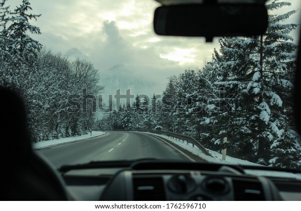 Road trip in the car driving through snowy\
mountains in Tirol,\
Austria
